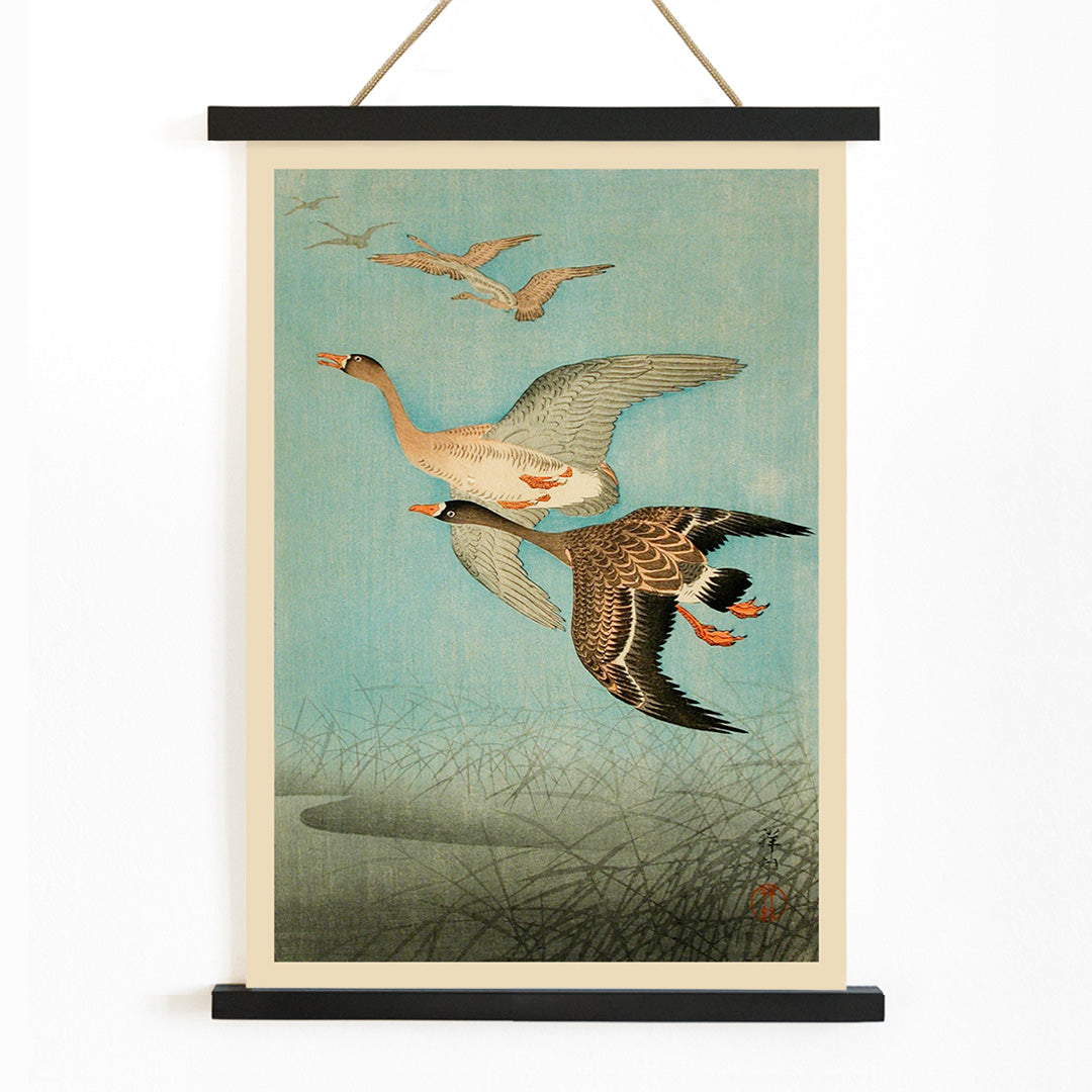Flying Geese by Ohara Koson Japanese woodblock print poster with two geese flying over water and reeds artwork wall art print, with wooden magnetic frame on white background