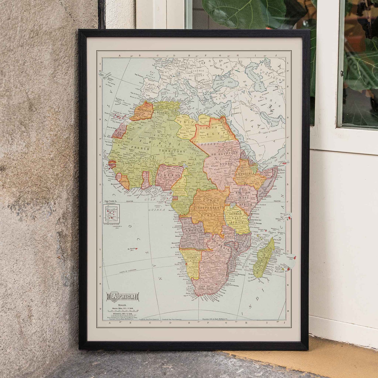 Rand McNally and Company Africa Map vintage poster of the African continent in muted green yellow pink and beige tones, framed and displayed in home decor