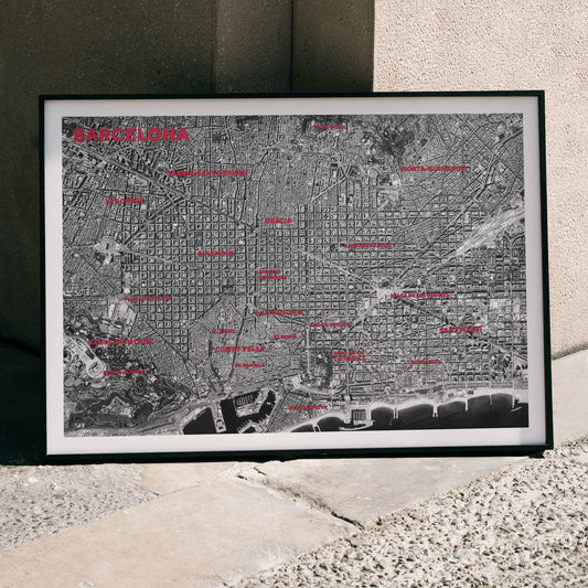 Moryarty Barcelona satellite city map poster in bold black and white aerial style showing city grid districts landmarks monuments and coastline, framed and displayed in home decor