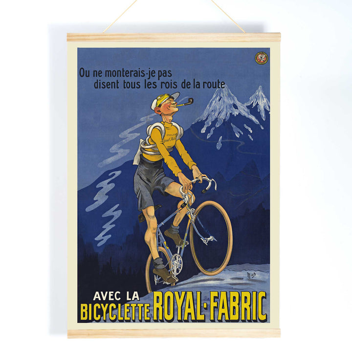 Michel Liebeaux Royal-Fabric bicycle poster with cyclist riding uphill in yellow gear against a moody blue mountain sky, with wooden magnetic frame on white background