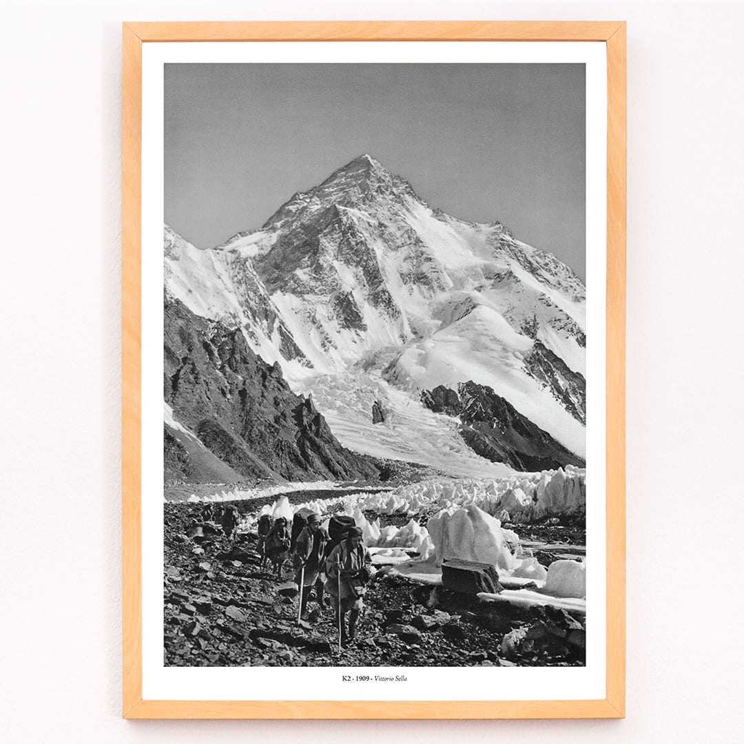 Black and white photo by Vittorio Sella of mountaineers trekking toward K2 over the Godwin Austen glacier titled Le pic K2 vue prise du glacier Godwin Austen, framed and displayed in modern living room decor