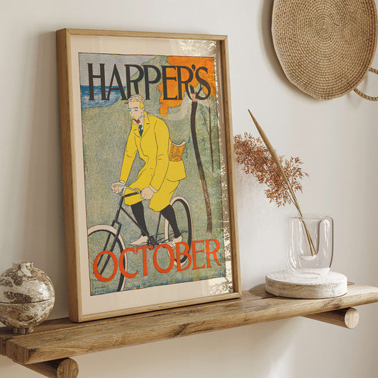 Man riding bicycle in autumn landscape wearing yellow outfit Harper for October poster by Edward Penfield with title displayed at top and bottom, framed and displayed in home decor