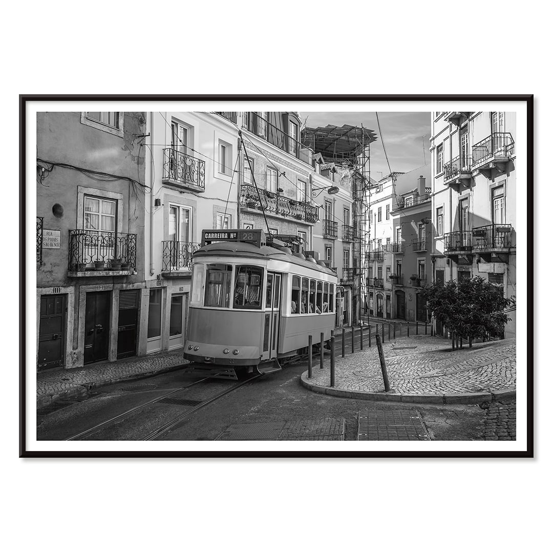 Lisbon Tramway 28 Black and White historic tram navigating cobblestone streets in Lisbon street scene poster, with black aluminium frame on white background