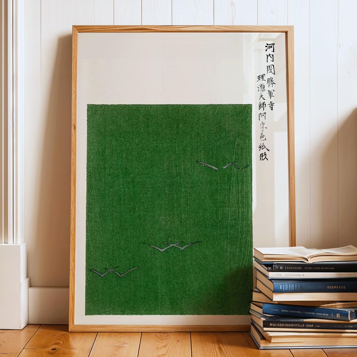 Minimalist Japanese vintage woodblock print poster of green field with birds by Taguchi Tomoki from Yatsuo no tsubaki, framed and displayed in modern living room decor